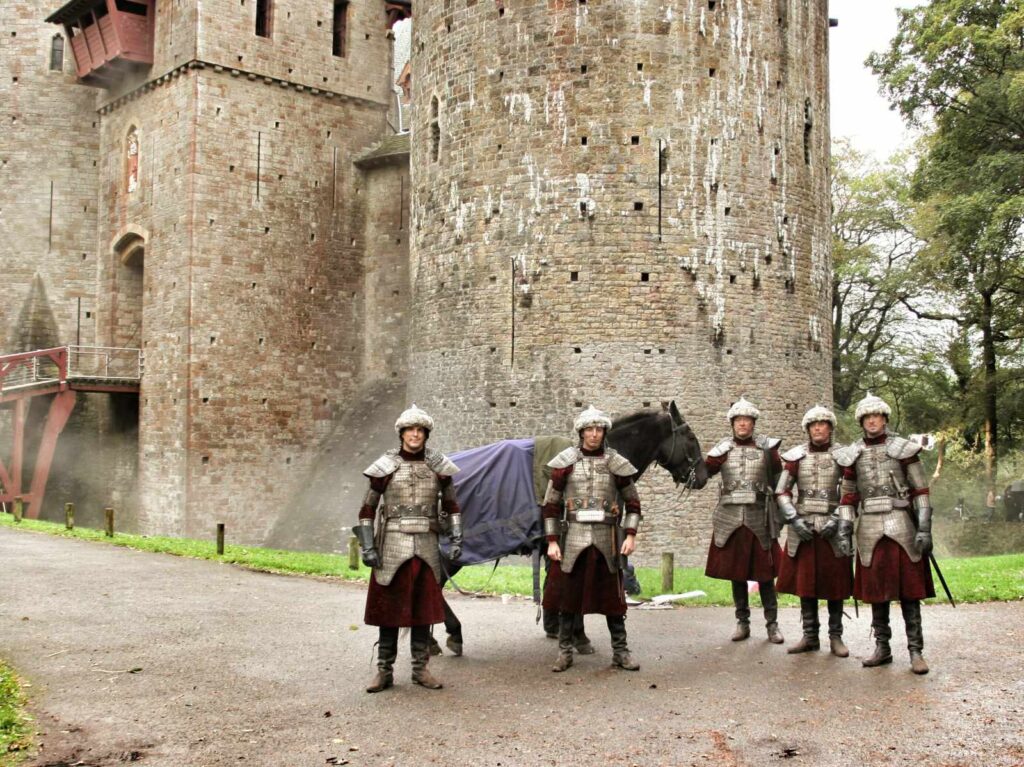 Actors dressed as soldiers on a TV filming set with Castell Coch in the background